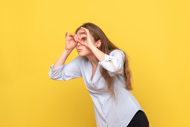 Vue de face de la jeune femme regardant à travers les doigts