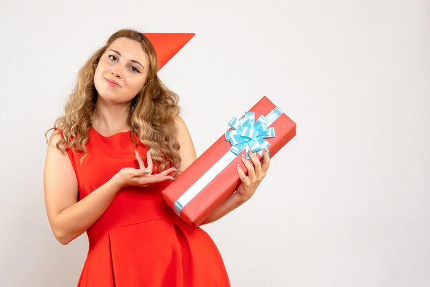 Vue de face jeune femme en robe rouge célébrant Noël avec présent