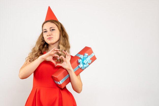 Vue de face jeune femme en robe rouge tenant le cadeau de Noël