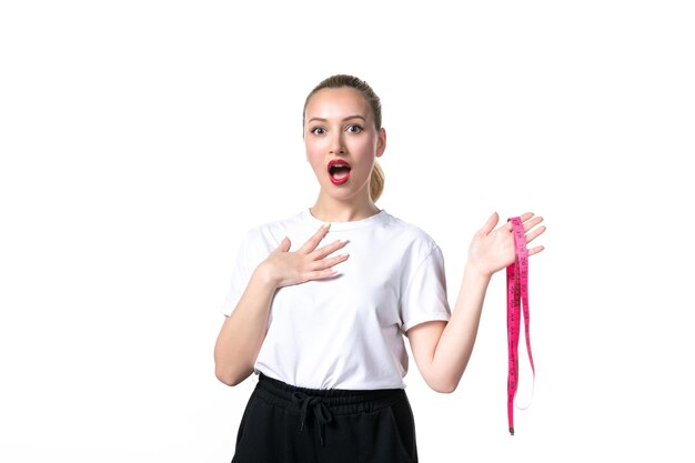 Vue de face jeune femme avec ruban à mesurer sur fond blanc échelle taille peau mesurant minceur hanche torse perdre