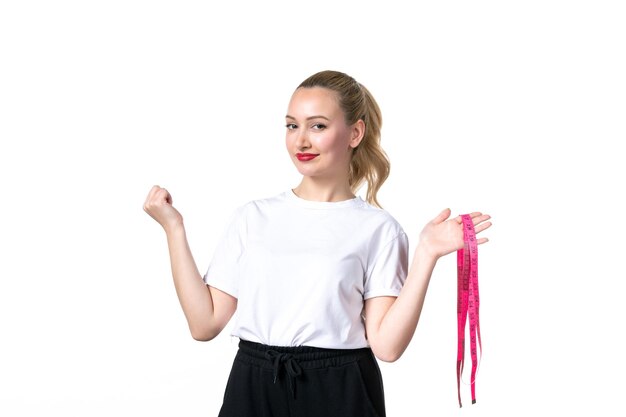 Vue de face jeune femme avec ruban à mesurer sur fond blanc taille de la peau mesurant perdre le poids du torse à l'échelle des hanches