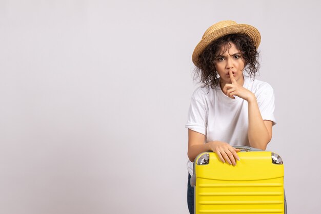 Vue de face jeune femme avec sac jaune se préparant au voyage sur fond blanc couleur vacances vol avion touristique reste voyage