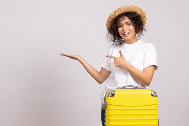 Vue de face jeune femme avec sac jaune se préparant au voyage sur fond blanc vol reste voyage vacances touristiques couleur soleil