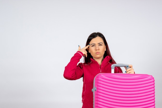 Vue de face jeune femme avec sac rose sur mur blanc couleur émotion vacances voyage vol voyage femme