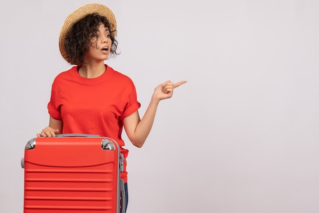 Vue de face jeune femme avec sac rouge se préparant au voyage sur fond blanc couleur avion repos vacances soleil vol voyage voyage