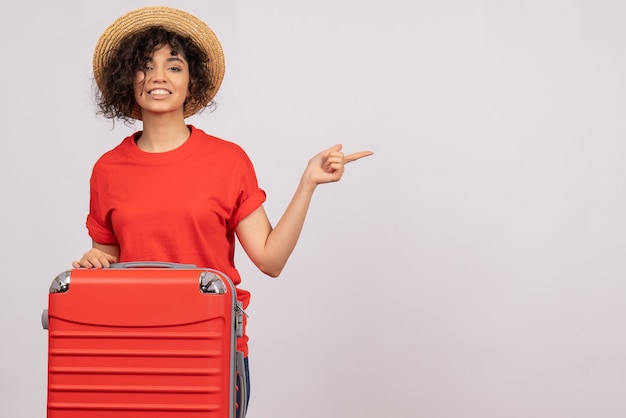 Vue de face jeune femme avec sac rouge se préparant au voyage sur fond blanc couleur avion repos vacances soleil vol voyage voyage