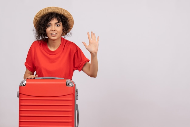 Vue de face jeune femme avec sac rouge se préparant au voyage sur fond blanc vacances couleur soleil voyage reste avion de vol touristique
