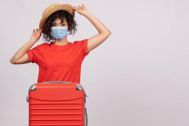 Vue de face jeune femme avec sac se préparant au voyage sur fond blanc couleur covid- voyage vacances touristiques virus du soleil pandémique