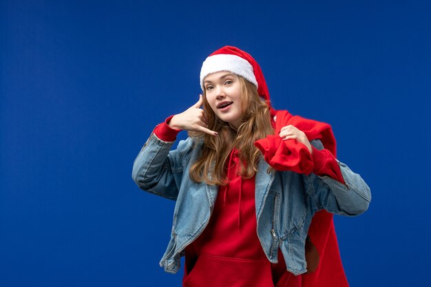 Photo gratuite vue de face jeune femme sac de transport plein de cadeaux sur l'espace bleu