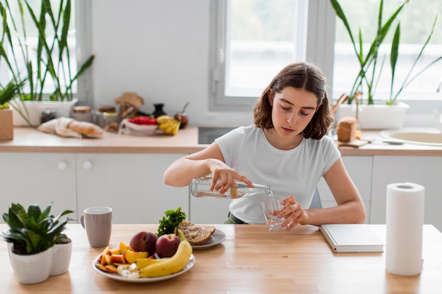 Vue de face jeune femme se détendre dans la cuisine