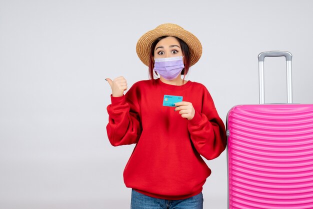 Vue de face jeune femme se préparant au voyage en masque sur mur blanc