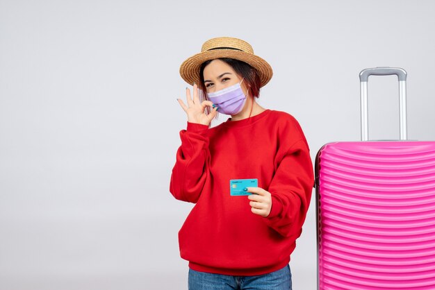 Vue de face jeune femme se préparant au voyage en masque sur mur blanc