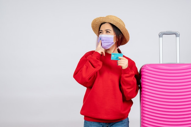 Vue de face jeune femme se préparant au voyage en masque sur mur blanc