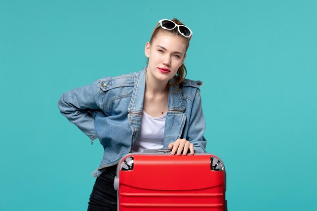 Vue de face jeune femme se préparant pour des vacances sur l'espace bleu