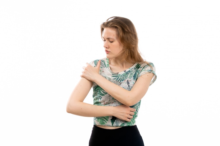 Photo gratuit une vue de face jeune femme séduisante en chemise conçue et pantalon noir souffrant de maux de bras sur le blanc