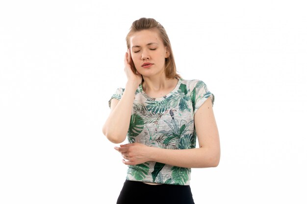 Une vue de face jeune femme séduisante en chemise conçue et pantalon noir souffrant de maux de tête sur le blanc