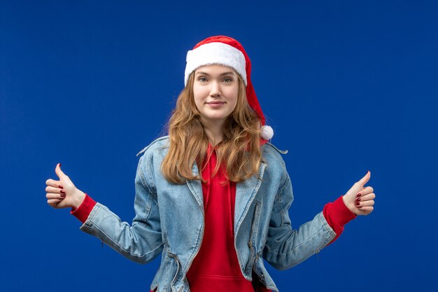 Vue de face jeune femme souriante sur fond bleu couleur des émotions de Noël