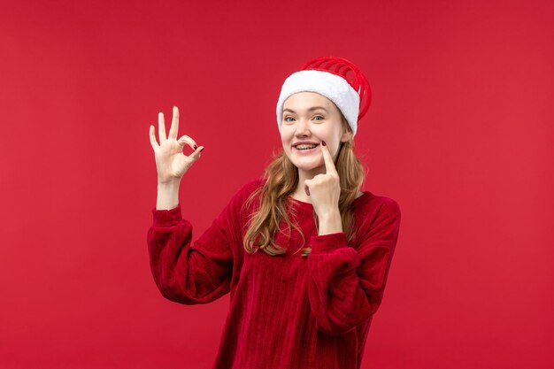 Vue de face jeune femme souriante joyeusement, vacances de Noël rouge