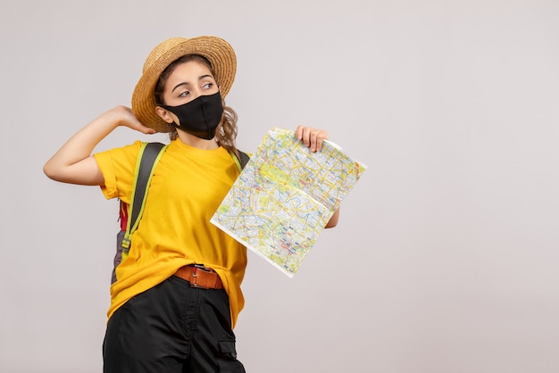 Vue de face jeune femme en t-shirt jaune brandissant la carte