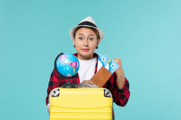 Vue de face jeune femme tenant des billets sur un bureau bleu