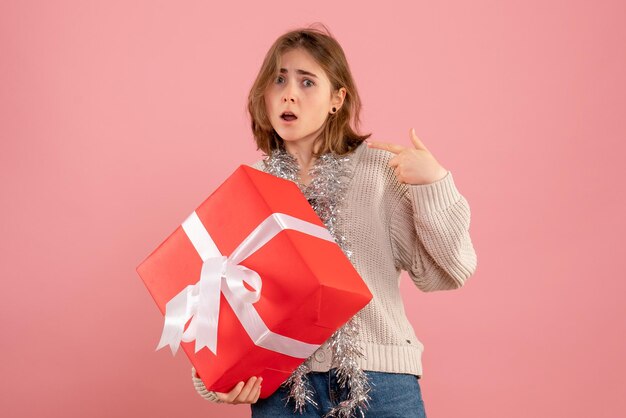 Vue de face jeune femme tenant cadeau de Noël