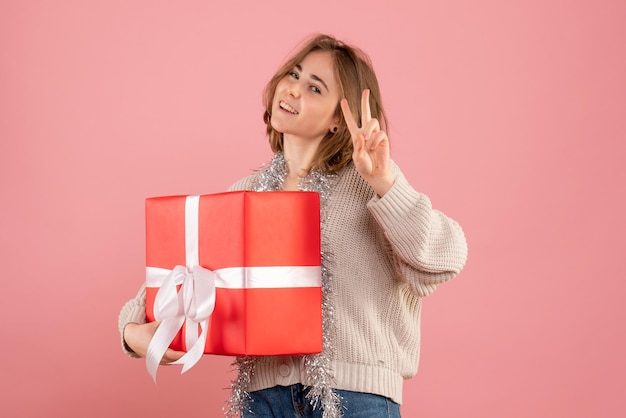 Vue de face jeune femme tenant cadeau de Noël