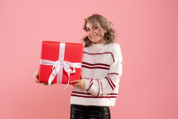 Vue de face jeune femme tenant cadeau de Noël