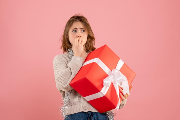 Vue de face jeune femme tenant cadeau de Noël