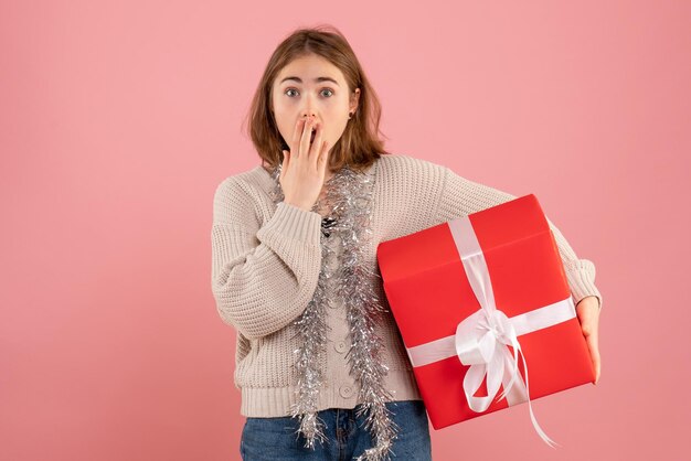 Vue de face jeune femme tenant cadeau de Noël