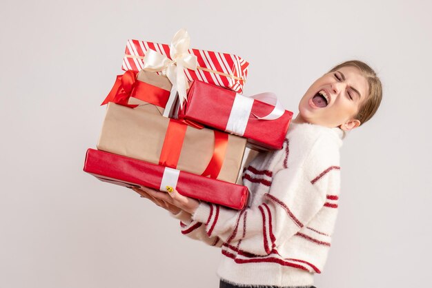 Vue de face jeune femme tenant des cadeaux de Noël