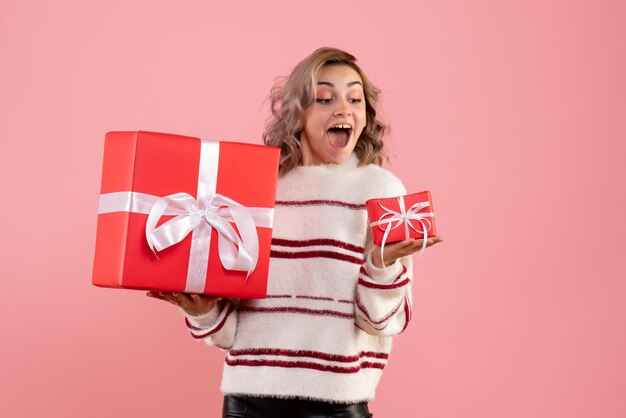 Vue de face jeune femme tenant des cadeaux de Noël