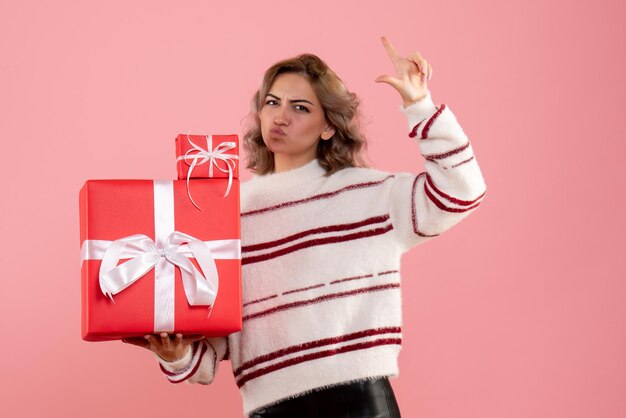 Vue de face jeune femme tenant des cadeaux de Noël