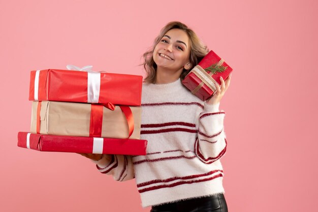 Vue de face jeune femme tenant des cadeaux de Noël