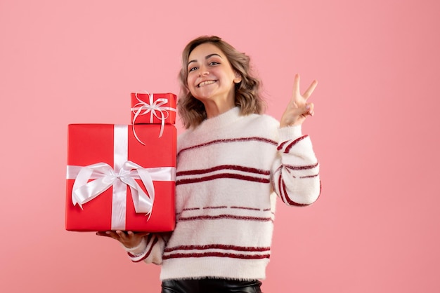 Vue de face jeune femme tenant des cadeaux de Noël