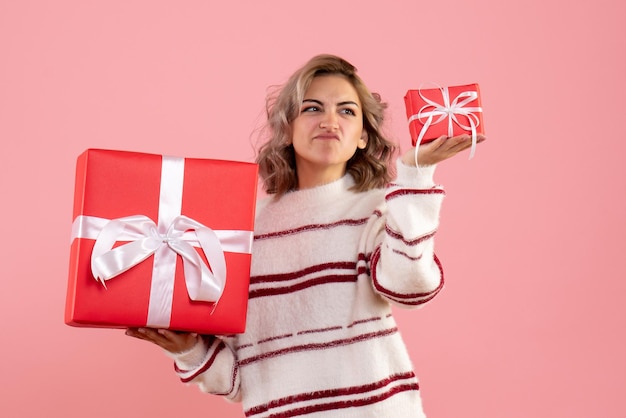 Vue de face jeune femme tenant des cadeaux de Noël