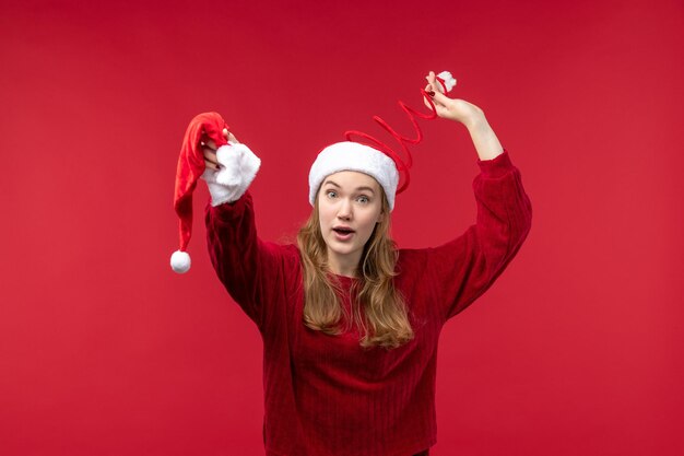 Vue de face jeune femme tenant une casquette rouge, Noël de vacances de Noël