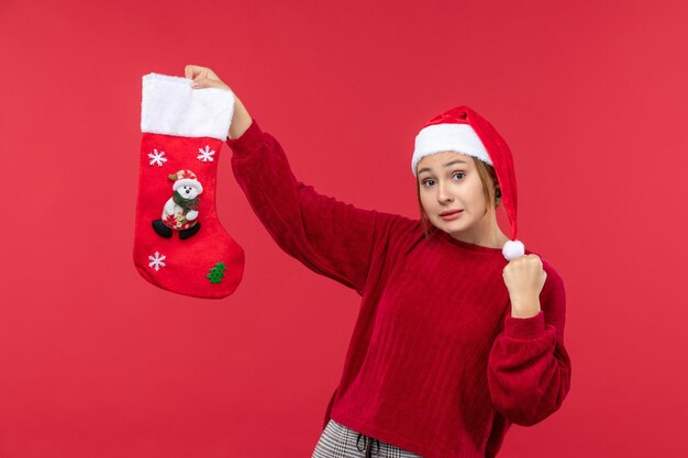 Vue de face jeune femme tenant la chaussette de Noël, vacances de Noël rouge