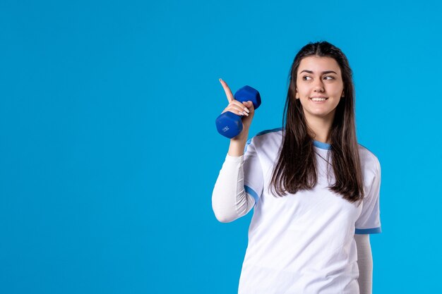 Vue de face jeune femme tenant des haltères bleus