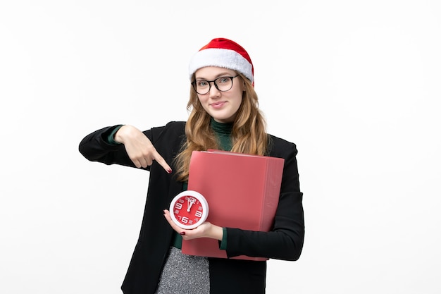 Vue de face jeune femme tenant horloge et fichiers sur le bureau blanc livre leçon college