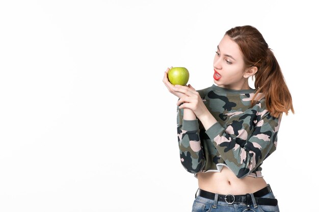 Vue de face jeune femme tenant pomme verte fond blanc fruits horizontaux régime soins de santé peau de jus de plat humain