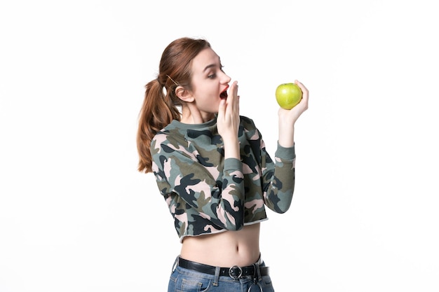 Vue de face jeune femme tenant pomme verte sur fond blanc repas arbre humain jus de fruits couleurs régime alimentaire plat