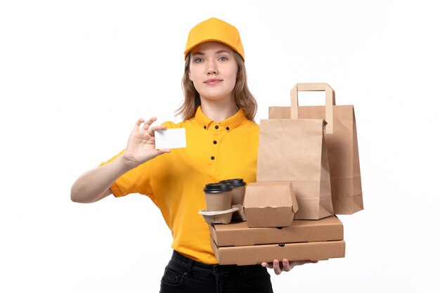 Une vue de face jeune femme travailleur de messagerie de service de livraison de nourriture tenant des paquets de nourriture tasses à café sur blanc