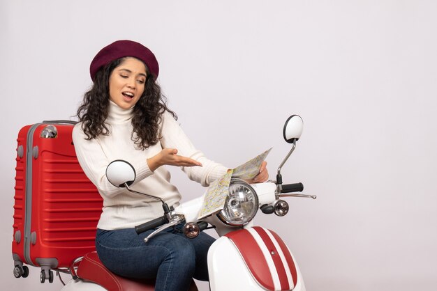 Vue de face jeune femme sur vélo tenant la carte sur fond blanc vol route véhicule ville vitesse couleur vacances