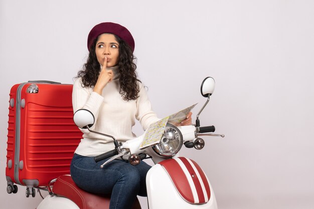 Vue de face jeune femme à vélo tenant la carte pensant sur fond blanc vol route moto vacances véhicule ville vitesse couleur