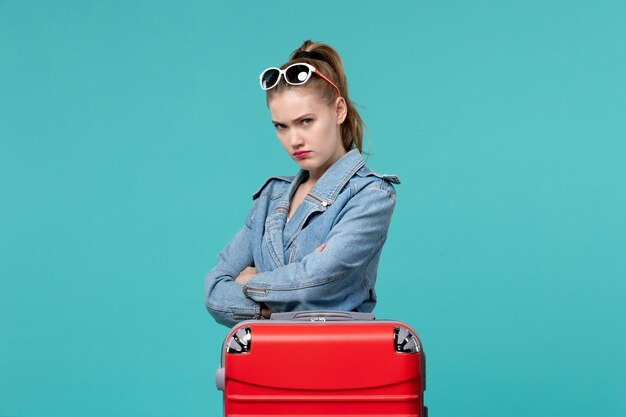 Vue de face jeune femme en veste bleue se prépare pour le voyage et se sentir en colère sur l'espace bleu