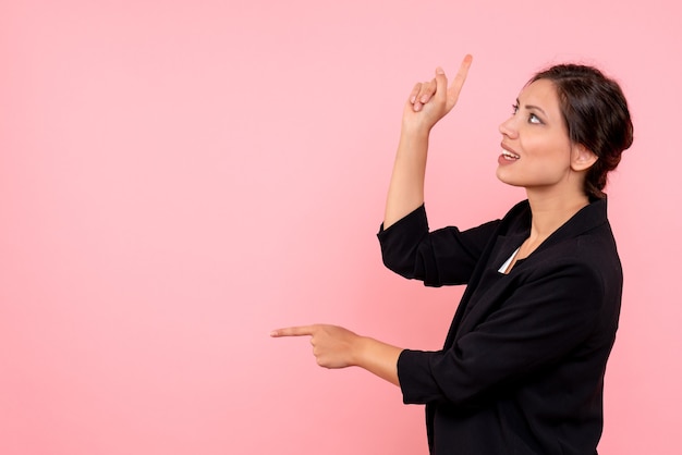 Vue de face jeune femme en veste sombre sur fond rose