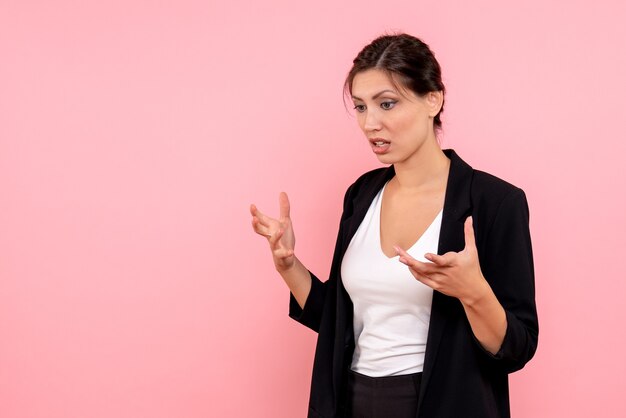 Vue de face jeune femme en veste sombre sur fond rose