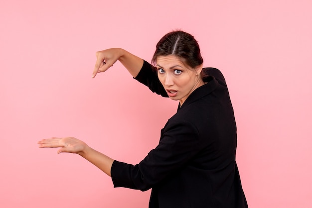 Photo gratuite vue de face jeune femme en veste sombre sur fond rose