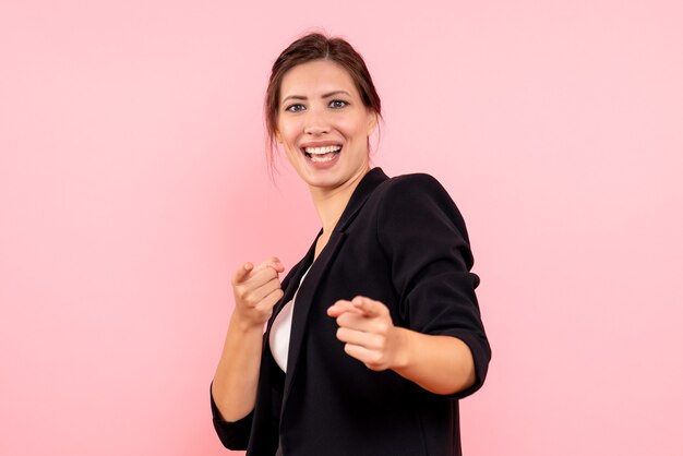 Vue de face jeune femme en veste sombre sur fond rose