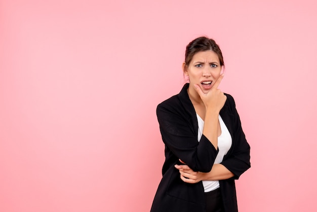 Vue de face jeune femme en veste sombre sur fond rose